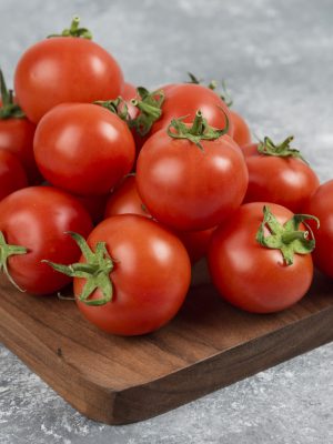 Bunch of red fresh tomatoes on wooden cutting board. High quality photo